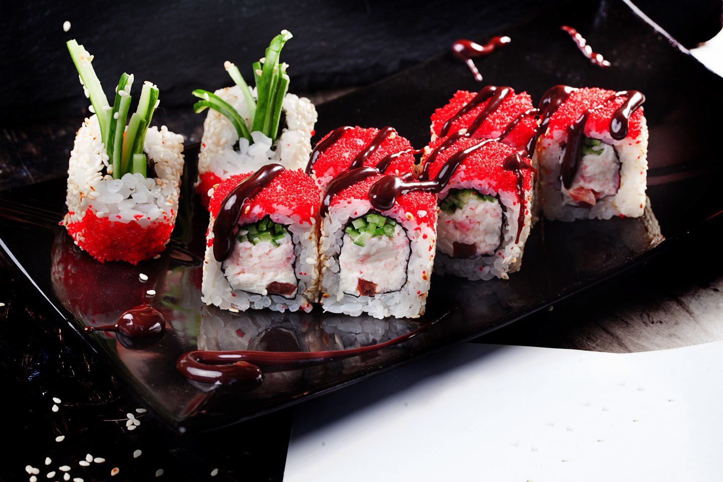 beautiful roll with crab, cucumber and tobiko caviar restaurant on black graphite board, sesame